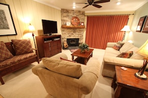 Relax by the fireplace in this inviting living room with two sofas, a coffee table, and a television.