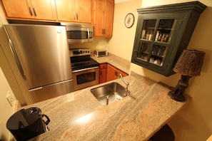 Efficient kitchen with modern appliances, stainless steel sink, and ample cabinetry.