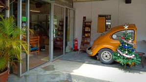 A Discovery Hostel entrance with a vintage car decorated with a Christmas tree and ornaments.