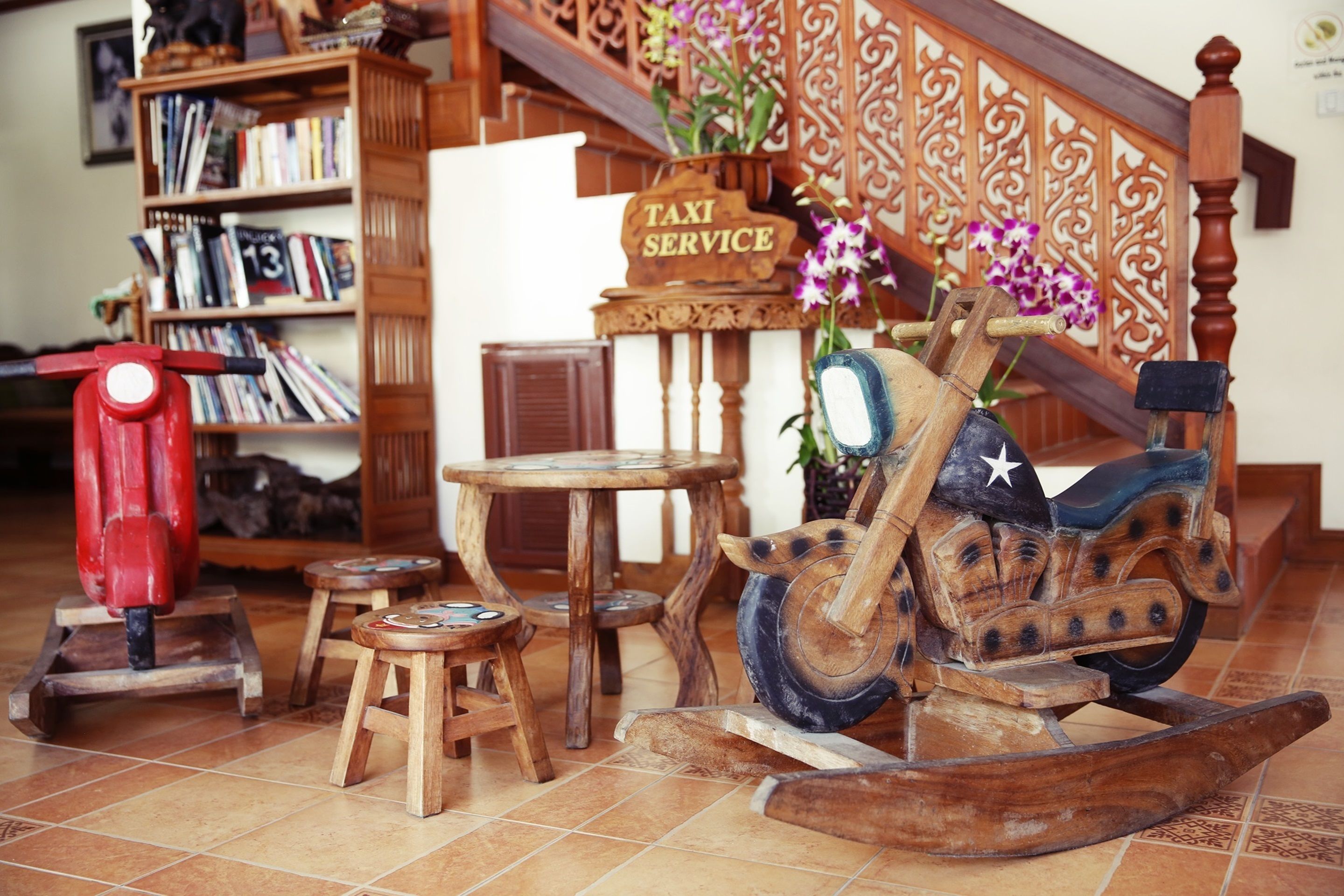 A wooden rocking horse, a wooden table, a wooden stool, a wooden bookshelf, and a wooden sign that reads "TAXI SERVICE".