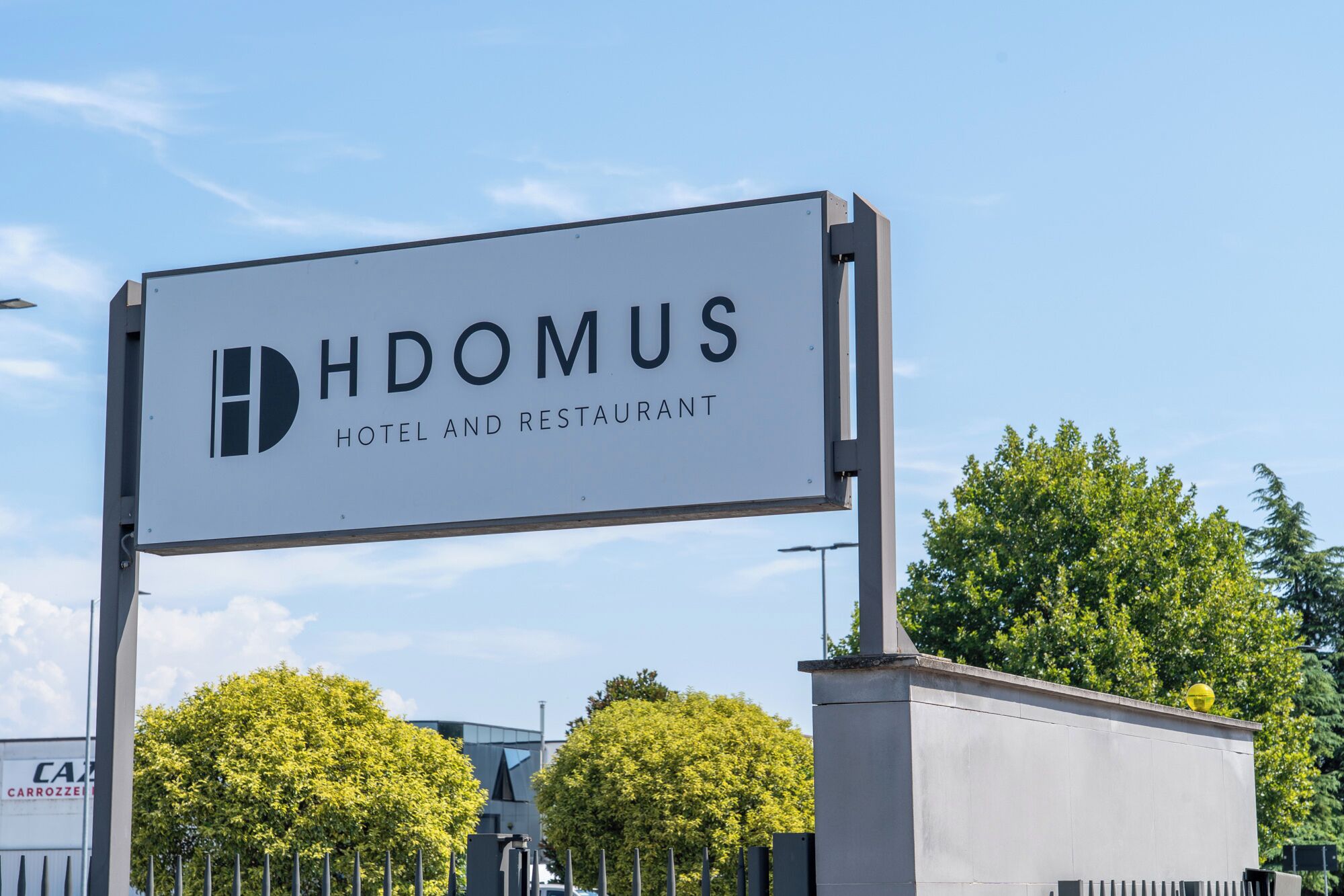A sign for HDOMUS HOTEL AND RESTAURANT.