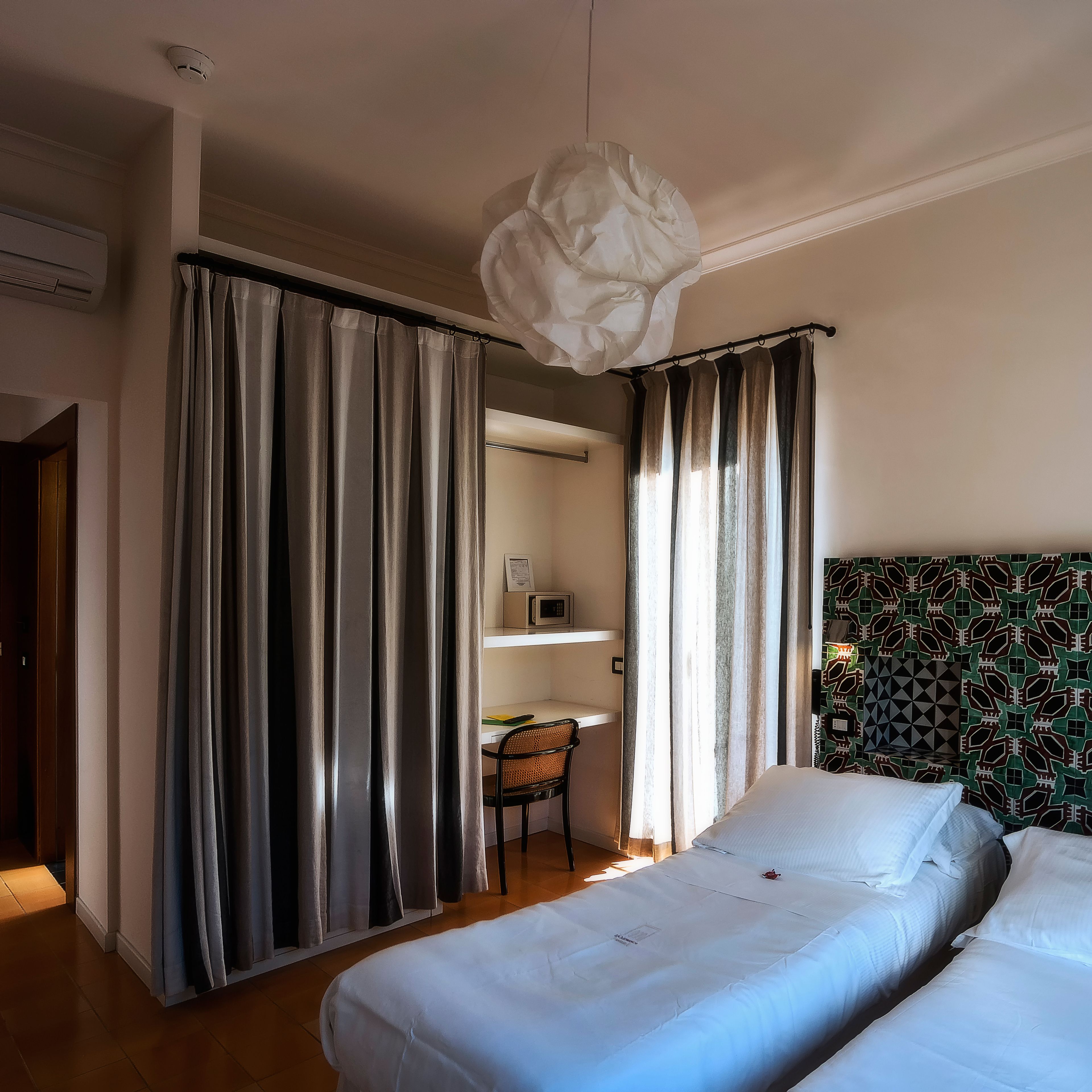 A bedroom with a bed, a desk, and a chair.