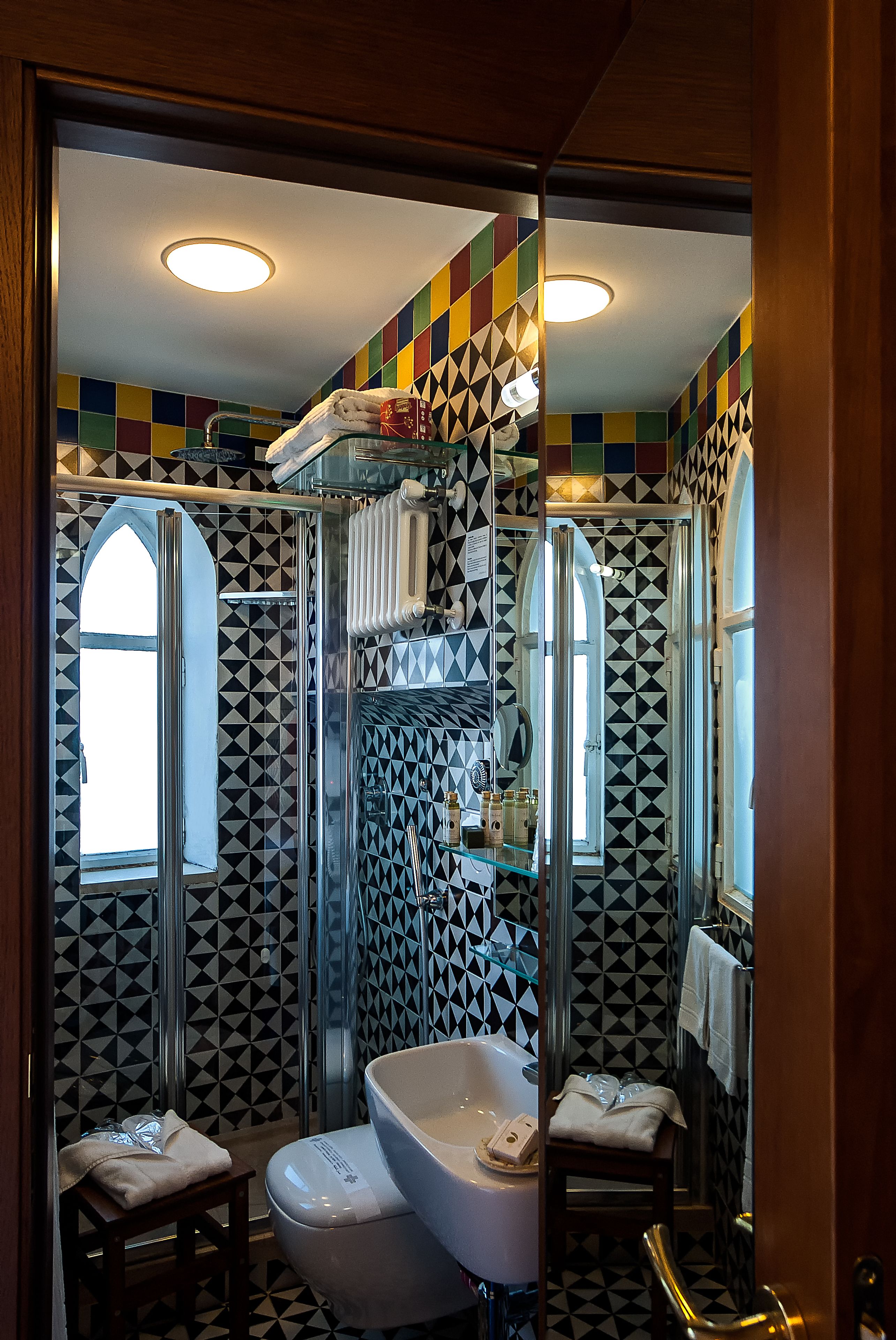 Un baño de diseño moderno, con una bañera independiente, cabina de ducha con mampara de vidrio y tocador con espejo.