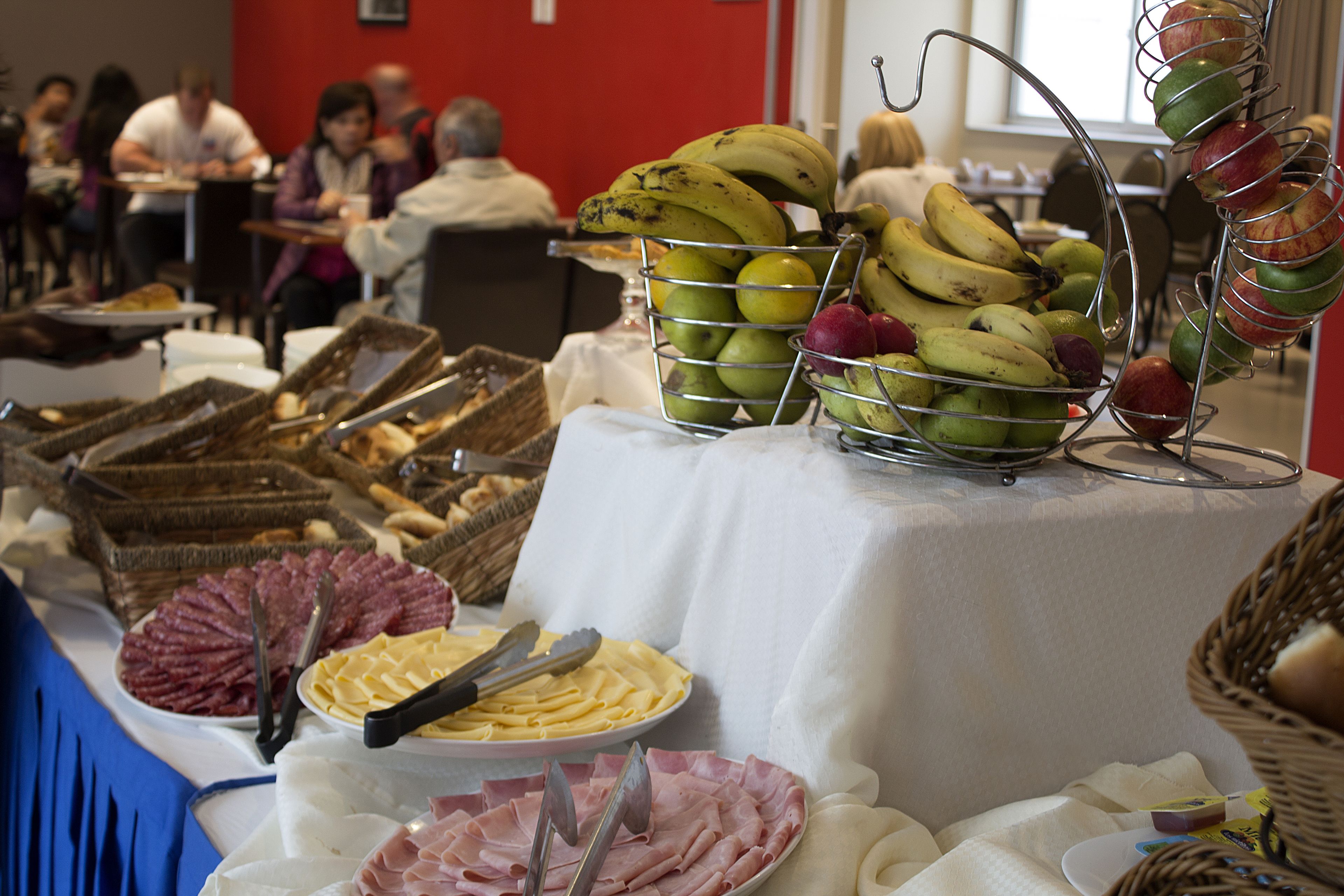 Un bufé con diversas opciones de comida, incluyendo frutas, quesos y embutidos.