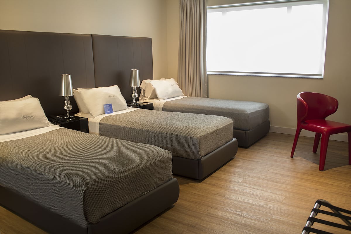 Deluxe Triple Room | Minibar, in-room safe, desk, blackout curtains