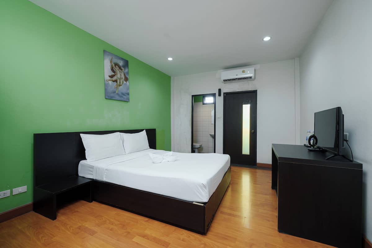 Una habitación de hotel con una cama, un escritorio y un televisor.