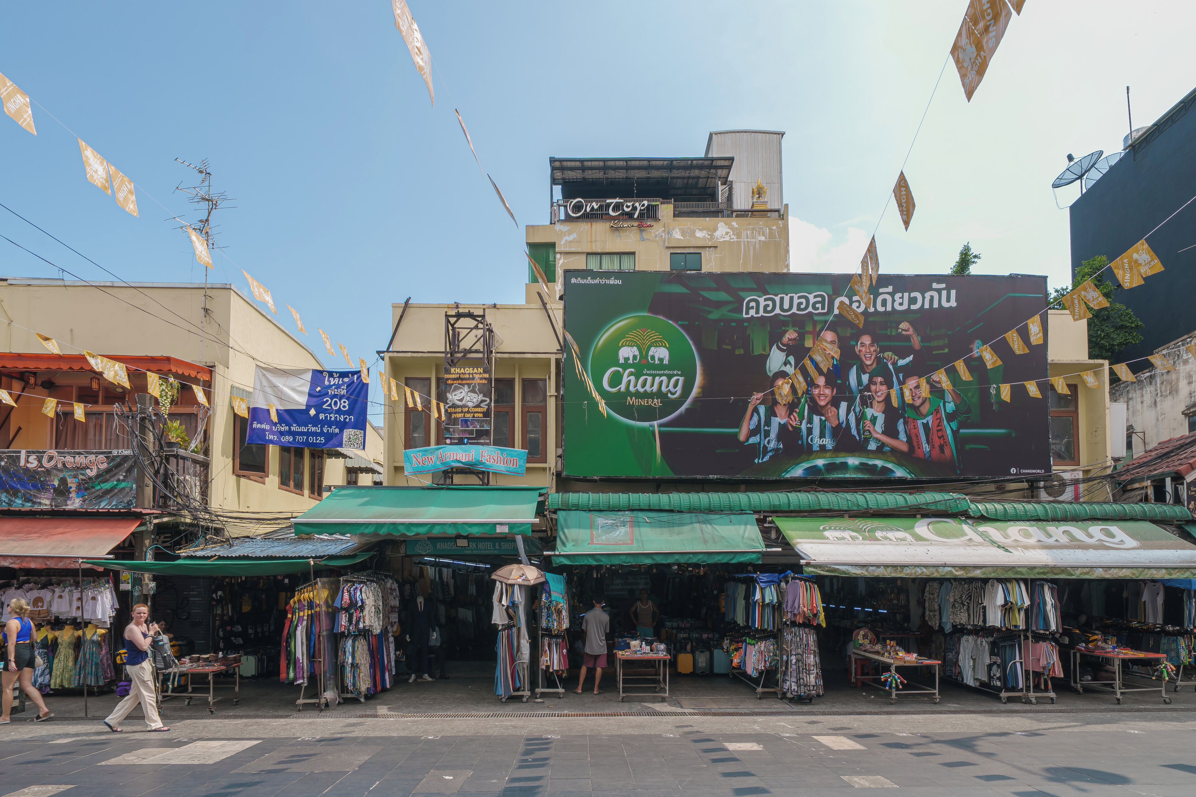 A street with shops and a large billboard advertising Chang mineral water.