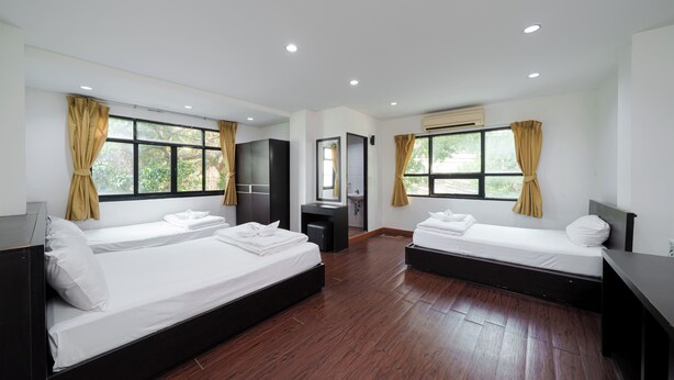 A hotel room with two beds, a small desk, a mirror, and a window with curtains. - Collection O Khaosan Park (Bangkok)