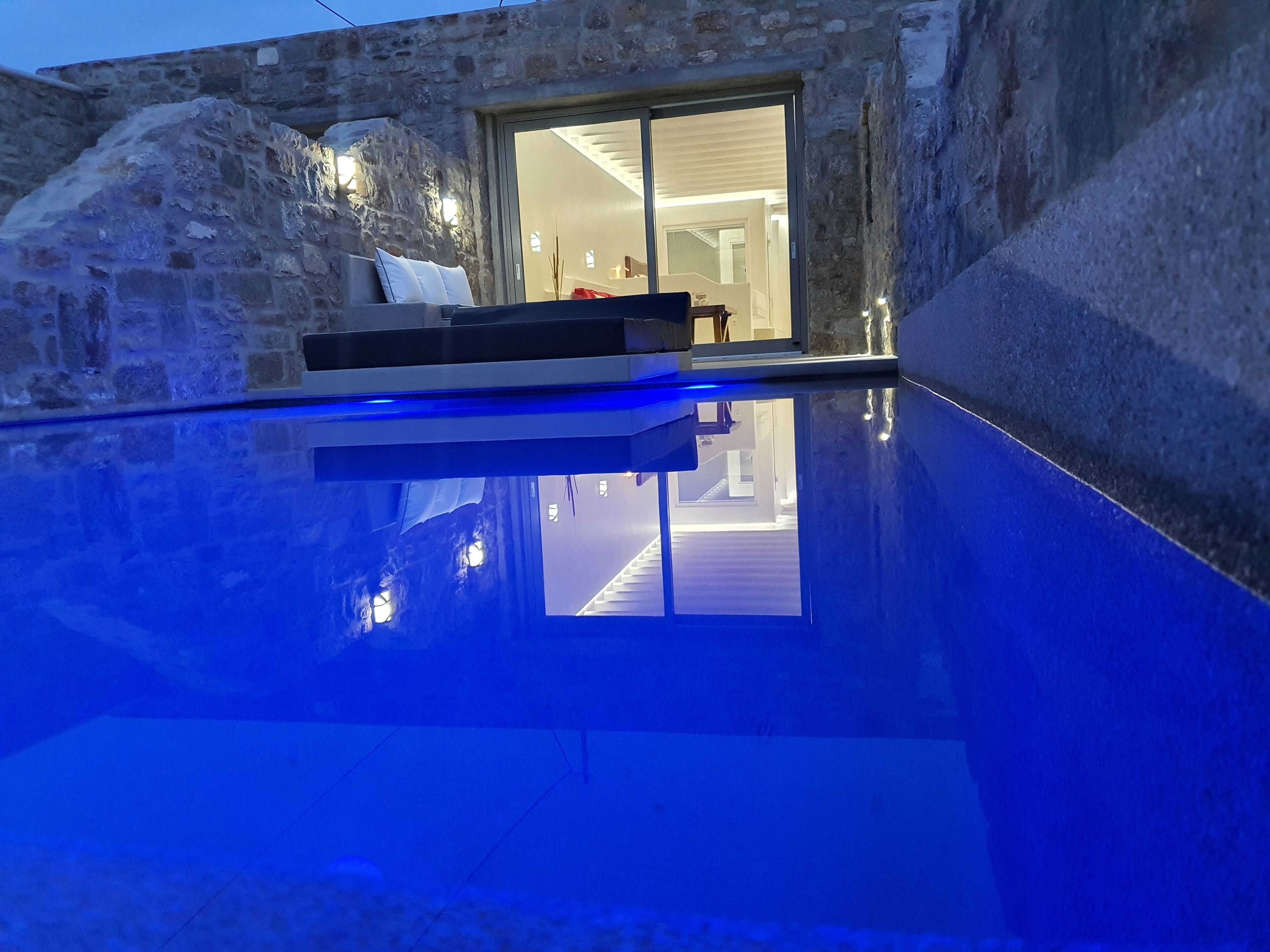 A stone building with a glass door leading to an interior space.