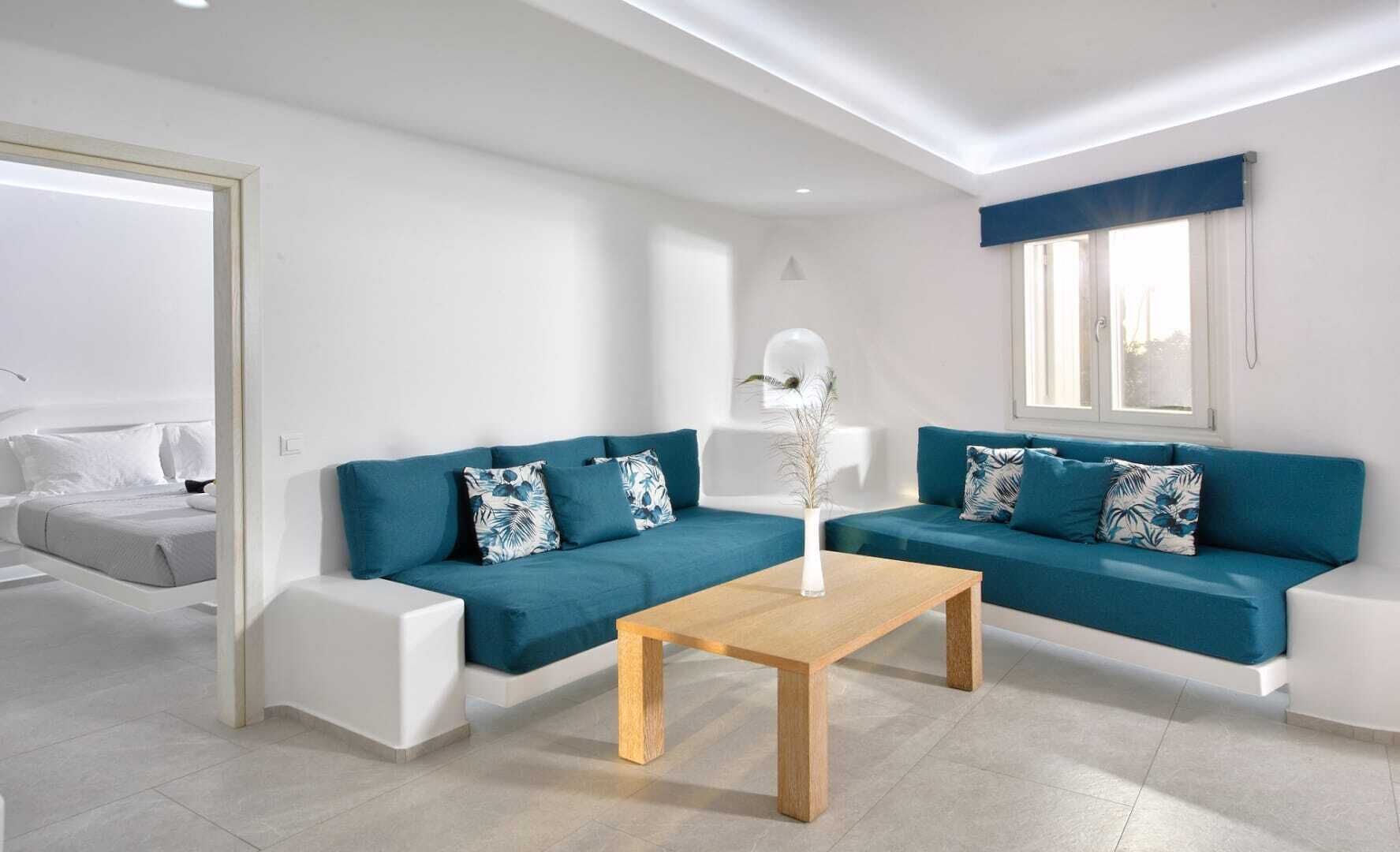A modern living room with two sofas, a coffee table, and a white wall.