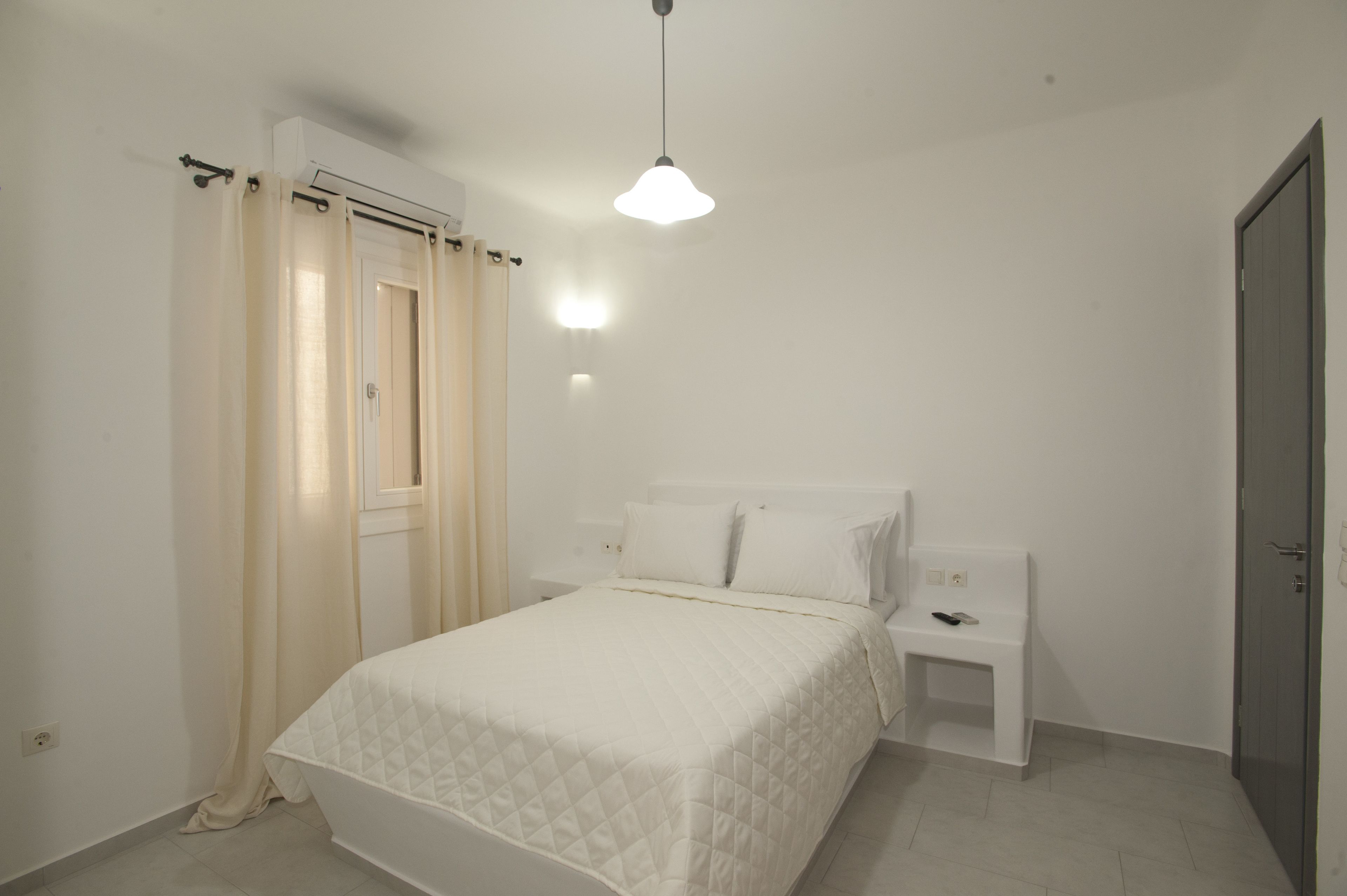 A bedroom with a bed, bedside table, and a wardrobe.