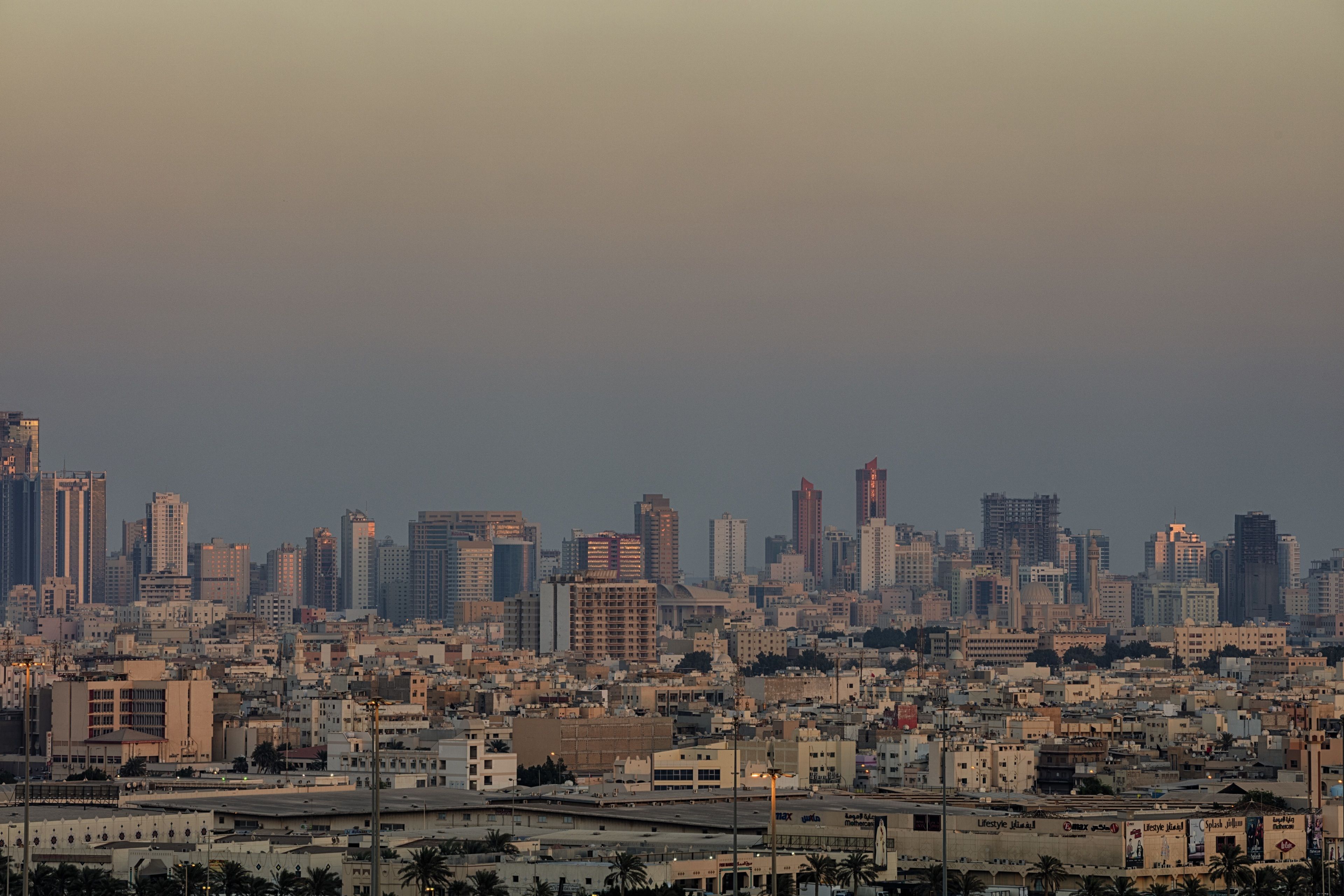A cityscape with a dense cluster of buildings, including high-rise structures and smaller residential buildings.
