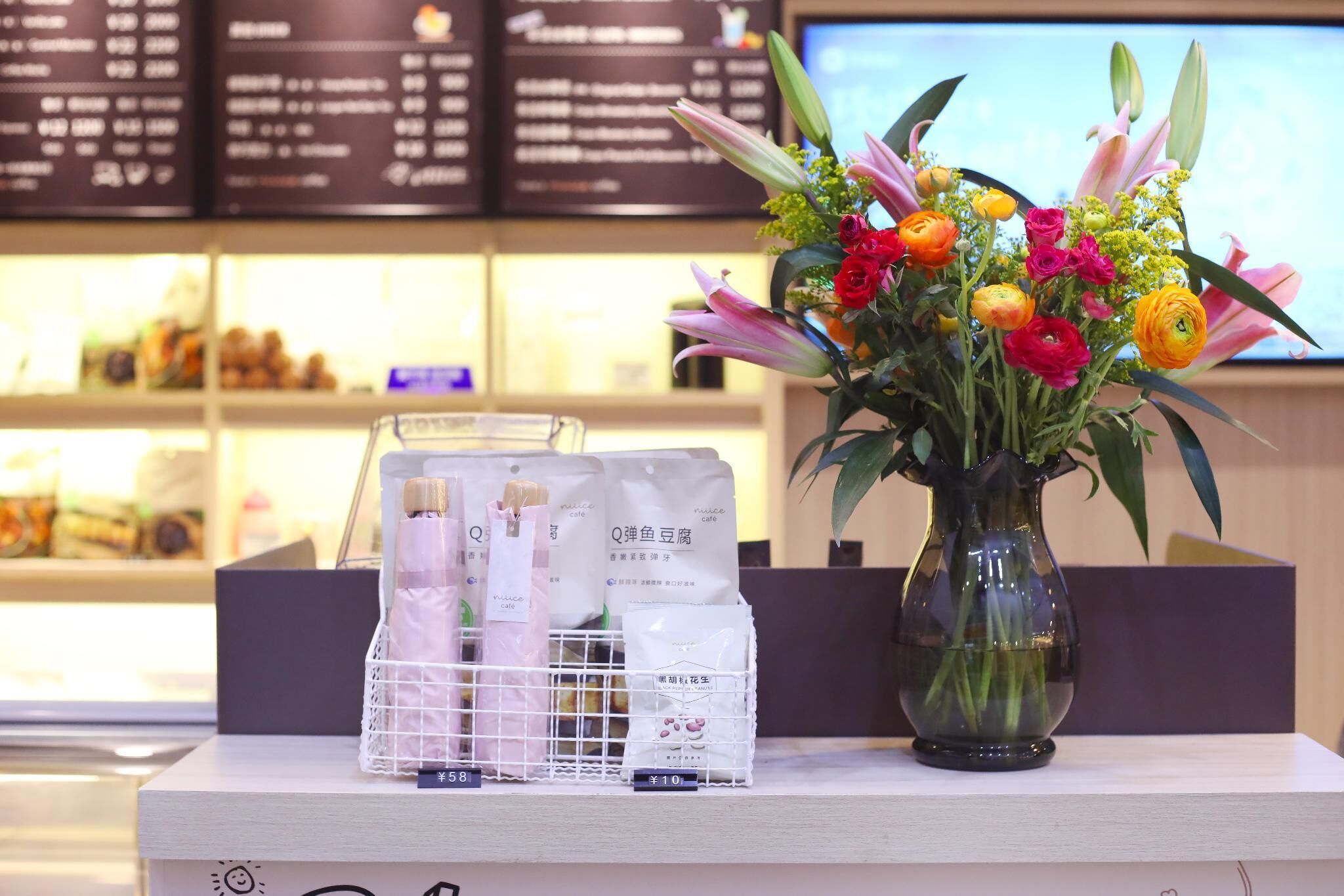 A display counter with a vase of flowers and packaged products.