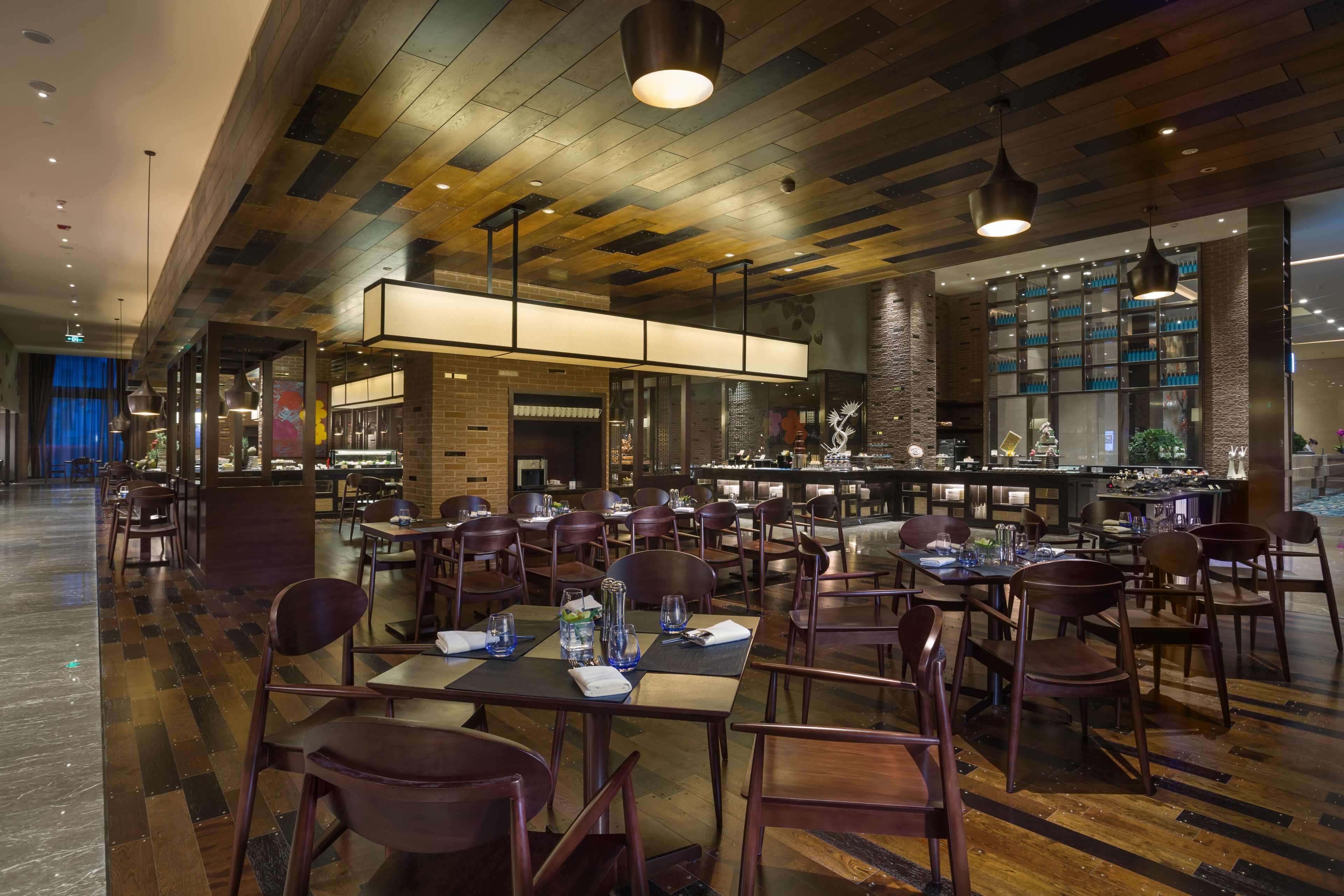A spacious restaurant with high ceilings, exposed beams, and a variety of seating arrangements.