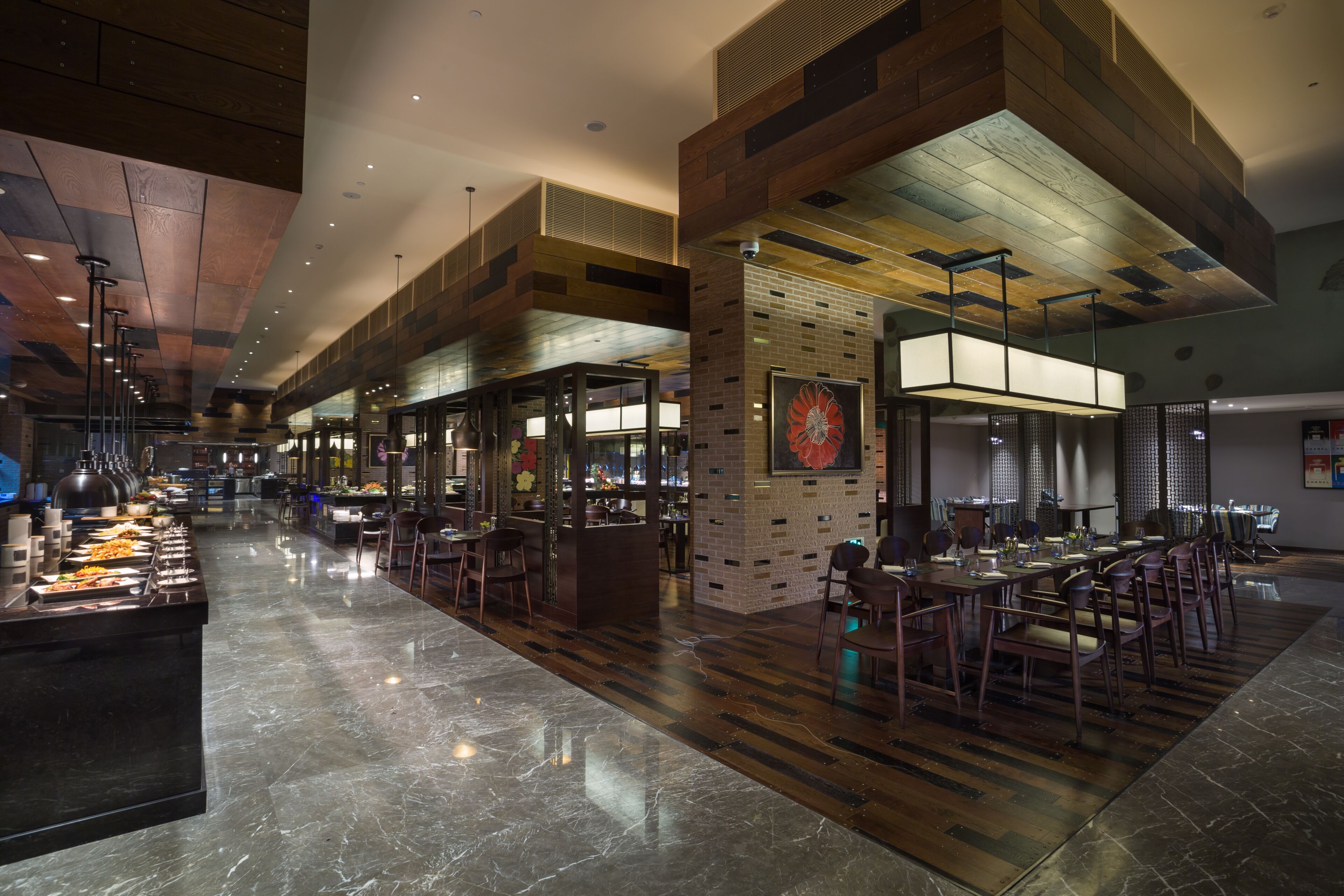 A spacious restaurant with a long counter, multiple seating areas, and a modern interior design.