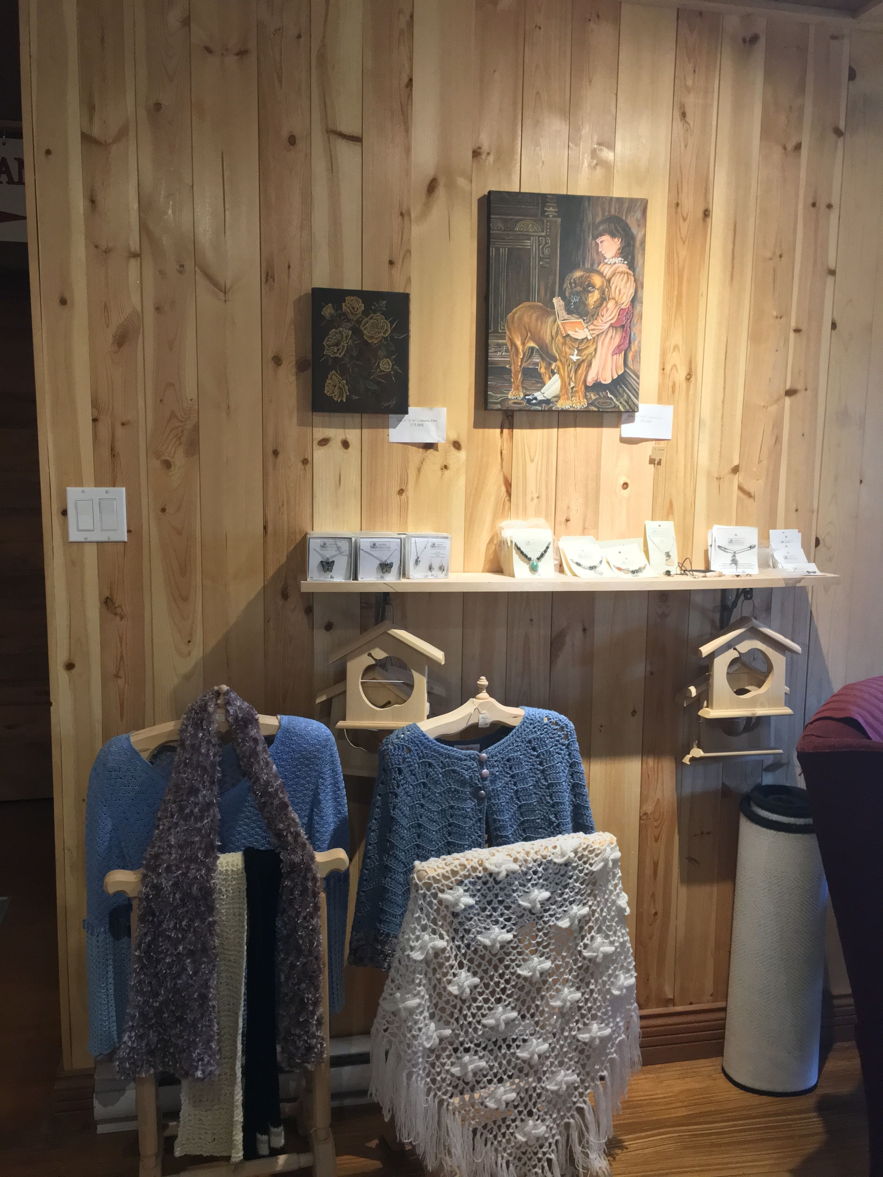 Un intérieur en bois avec des étagères où sont exposés des boîtes à bijoux et des articles tricotés.