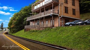 A two-story building with a balcony, a sign indicating it is a restaurant, and cars parked in front. - Auberge Le Four à Pain (Petite-Riviere-Saint-Francois)