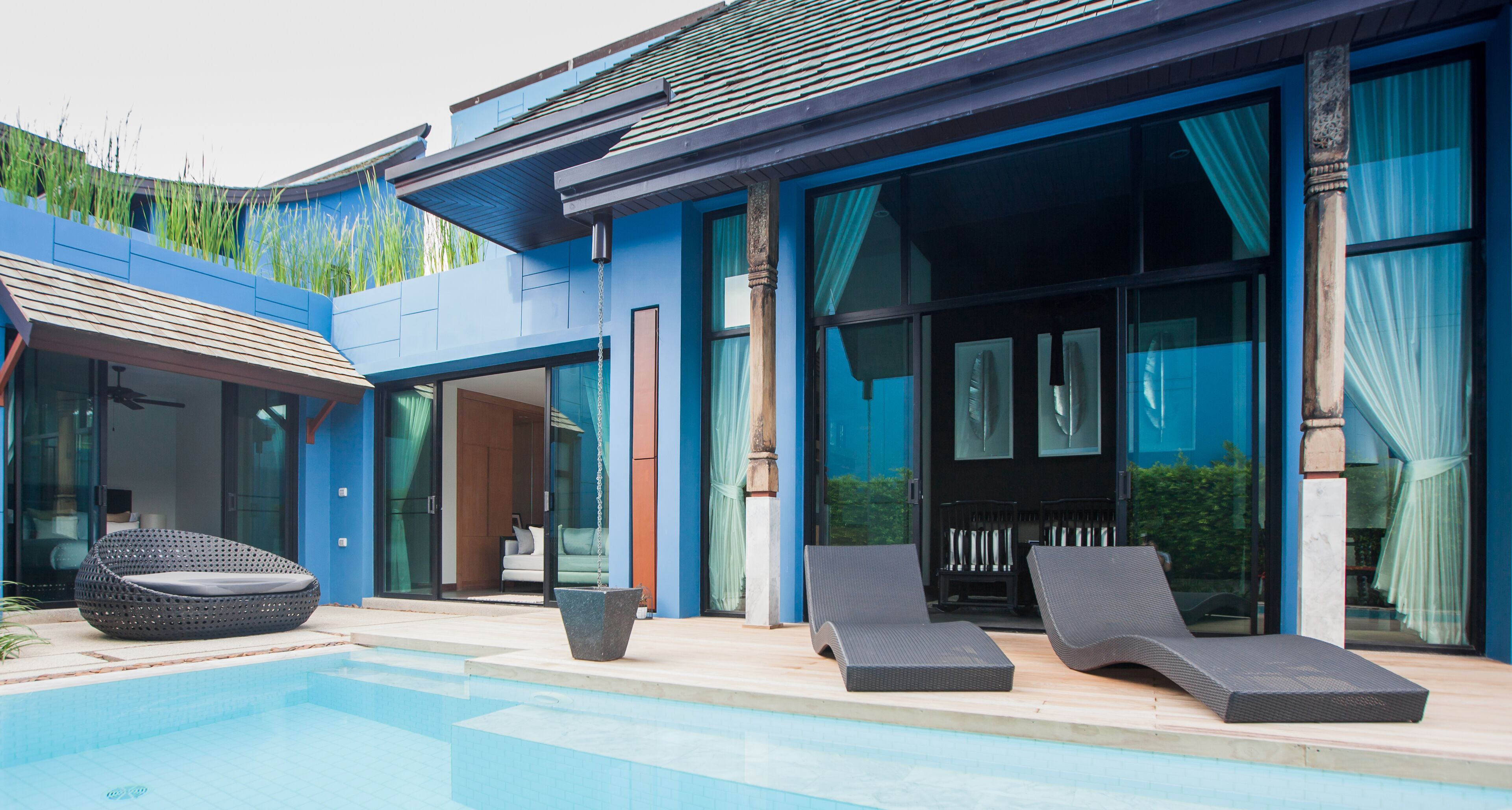 A modern poolside area with lounge chairs and a built-in seating area.