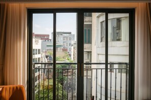 Vista desde un balcón con barandilla de metal, que da a una zona residencial con edificios y zonas verdes.