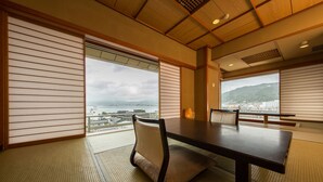 Una habitación japonesa tradicional con suelo de tatami, una mesa baja y puertas correderas.