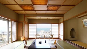 Una habitación tradicional japonesa con suelo de tatami, una mesa baja y puertas correderas.