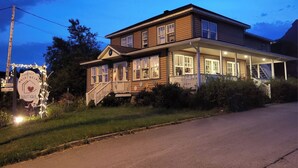 Egy kétszintes ház verandával, és egy táblával, amelyen a következő felirat olvasható: „Auberge Rosé Bel Air Boutique”.