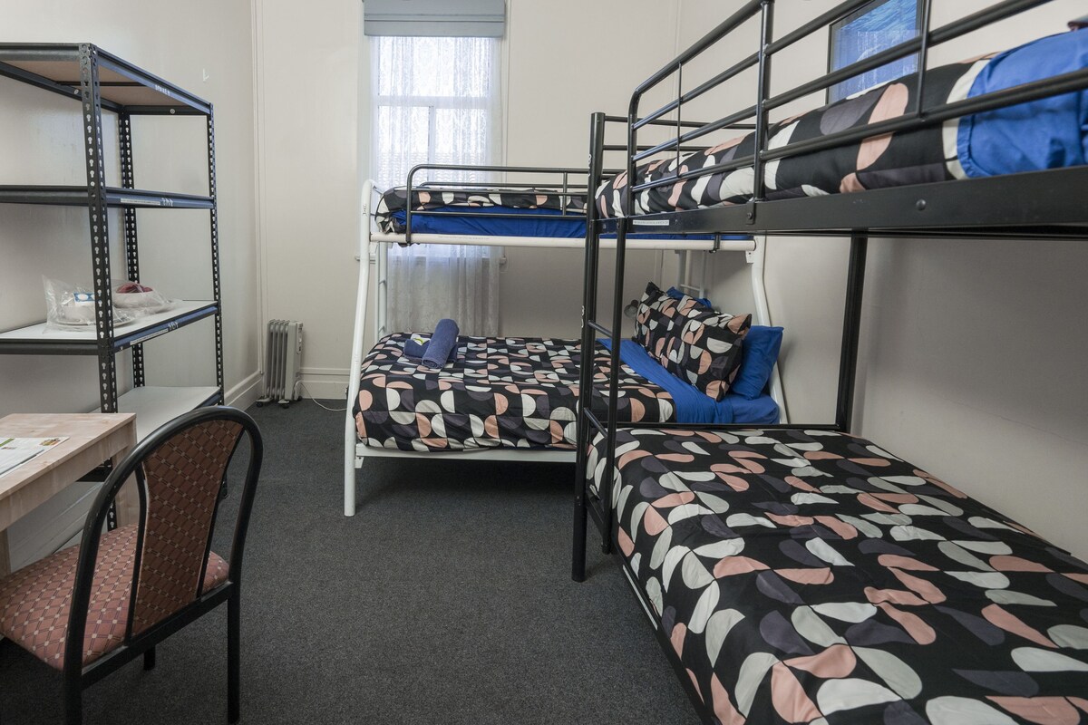 Un dormitorio con literas, un escritorio y una silla.