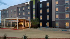 A multi-story hotel with a covered entrance and a parking area with handicapped spaces. - Home2 Suites by Hilton Houston/Katy (Katy)