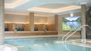 A modern indoor swimming pool with a tiled floor, wooden seating areas, and a large screen displaying a scenic lake view. - Landhaus Ager (Soell)