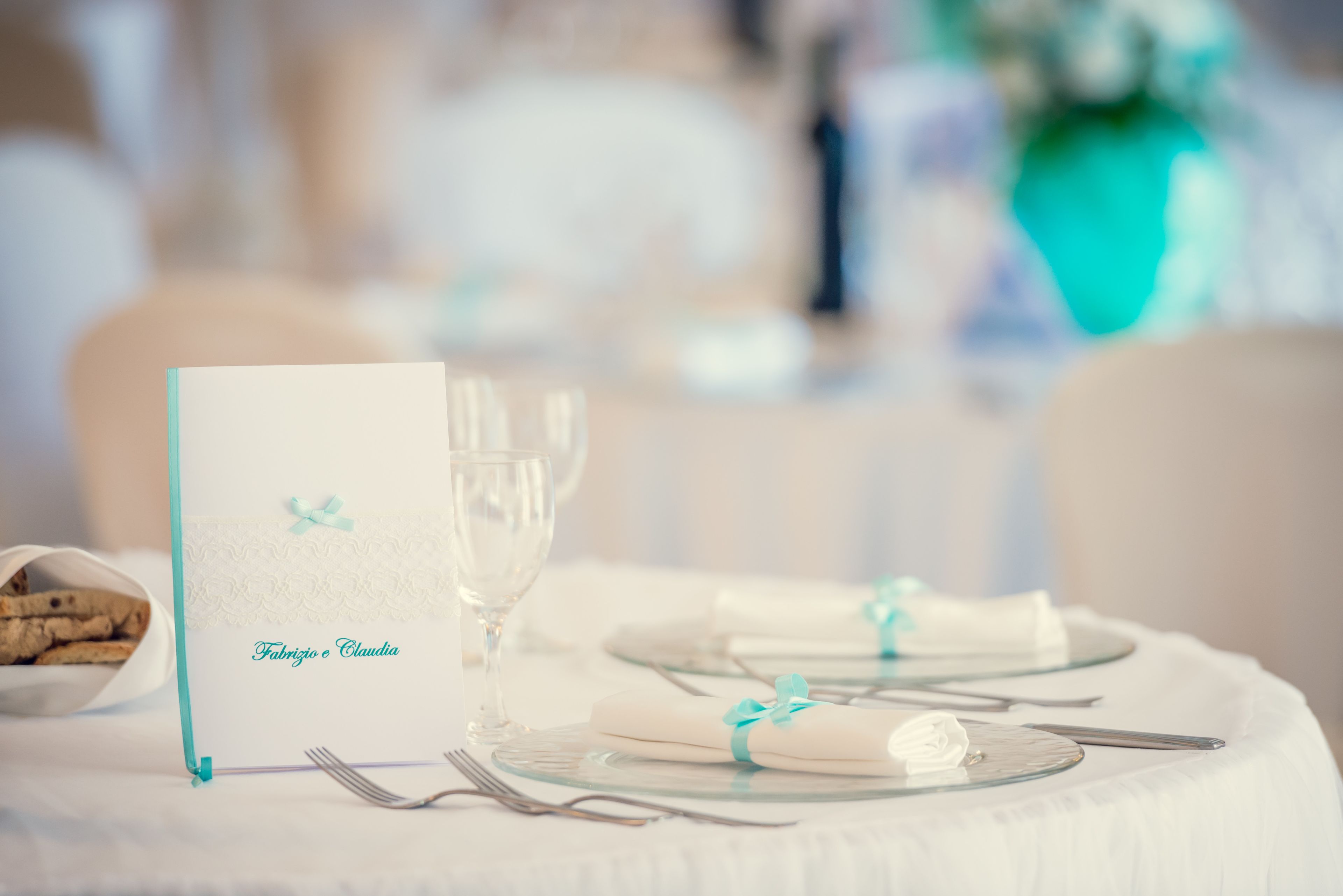 A table set for a meal with a menu card reading "Fabrizio e Claudia".
