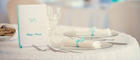 A table set for a meal with a menu card reading "Fabrizio e Claudia".