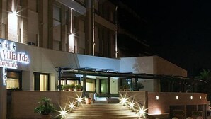 Hotel Villa Ida con un letrero destacado, un acceso cubierto y una escalera que conduce a la entrada.