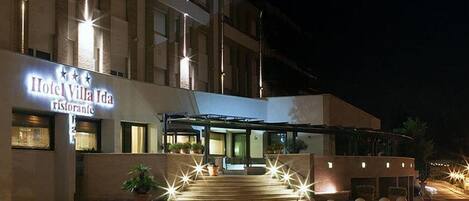 Hotel Villa Ida with a prominent sign, a covered entrance, and a staircase leading to the entrance.