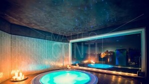 Un área de spa con un jacuzzi circular, un espejo grande y suelo de madera.
