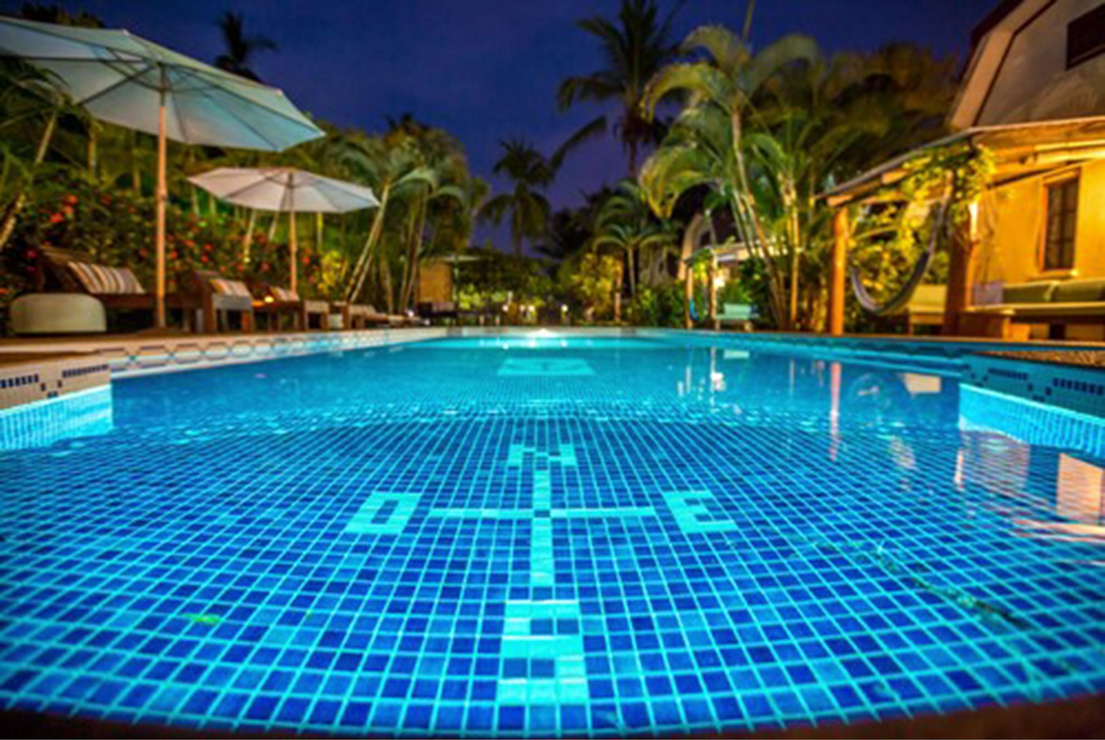 Una piscina al aire libre, sombrillas, tumbonas