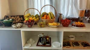 Un bufé con diversas frutas, verduras y salsas.
