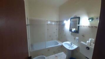 A small bathroom with a bathtub, a sink, and a toilet.