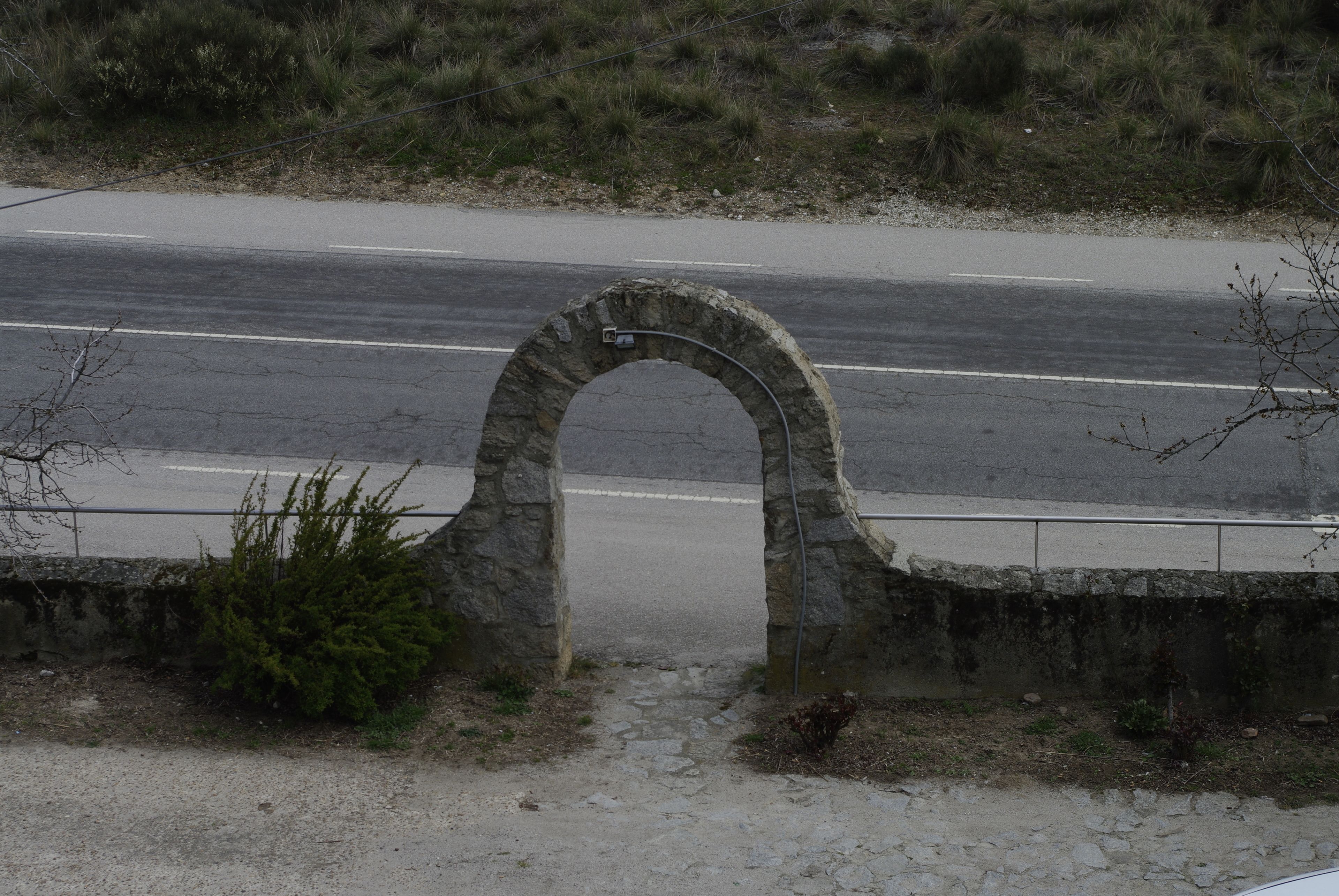 A stone archway leading to a road.