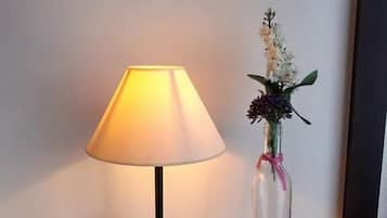 Una mesita de noche con una lámpara y un florero.
