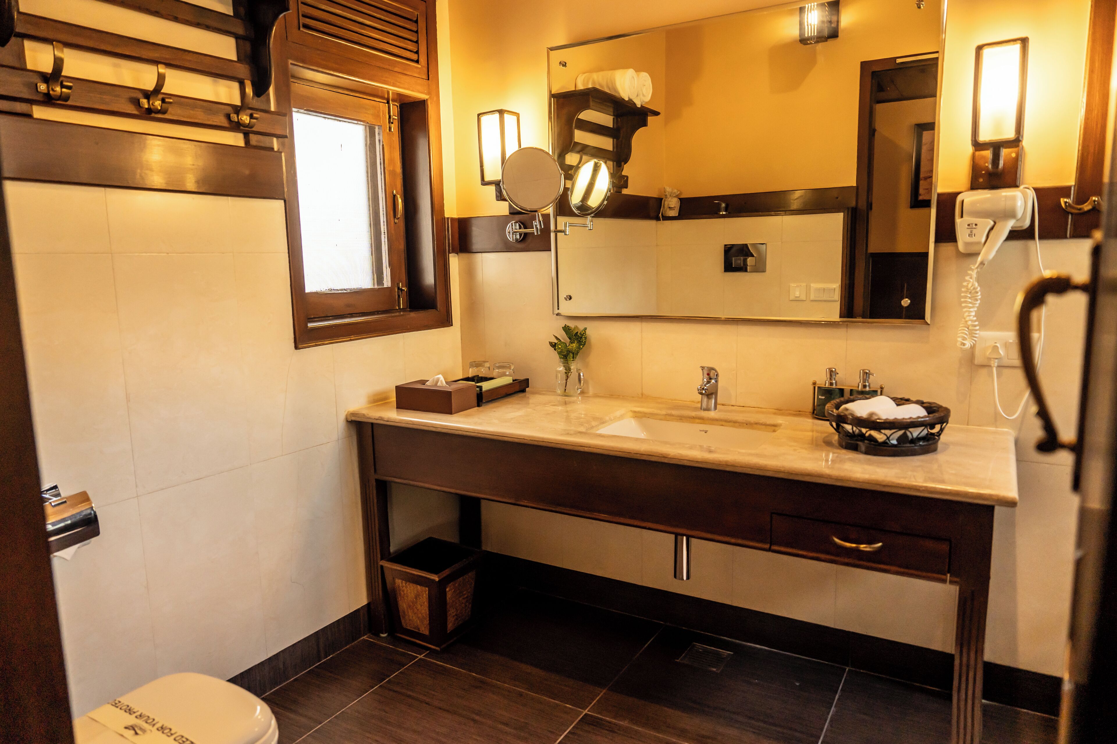 A modern bathroom with a large mirror, a sink, a vanity, and a hairdryer.