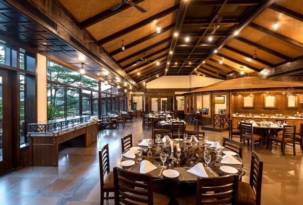 Un restaurant spacieux, doté de hauts plafonds, de grandes fenêtres et offrant différents types d’aménagements pour s’asseoir.