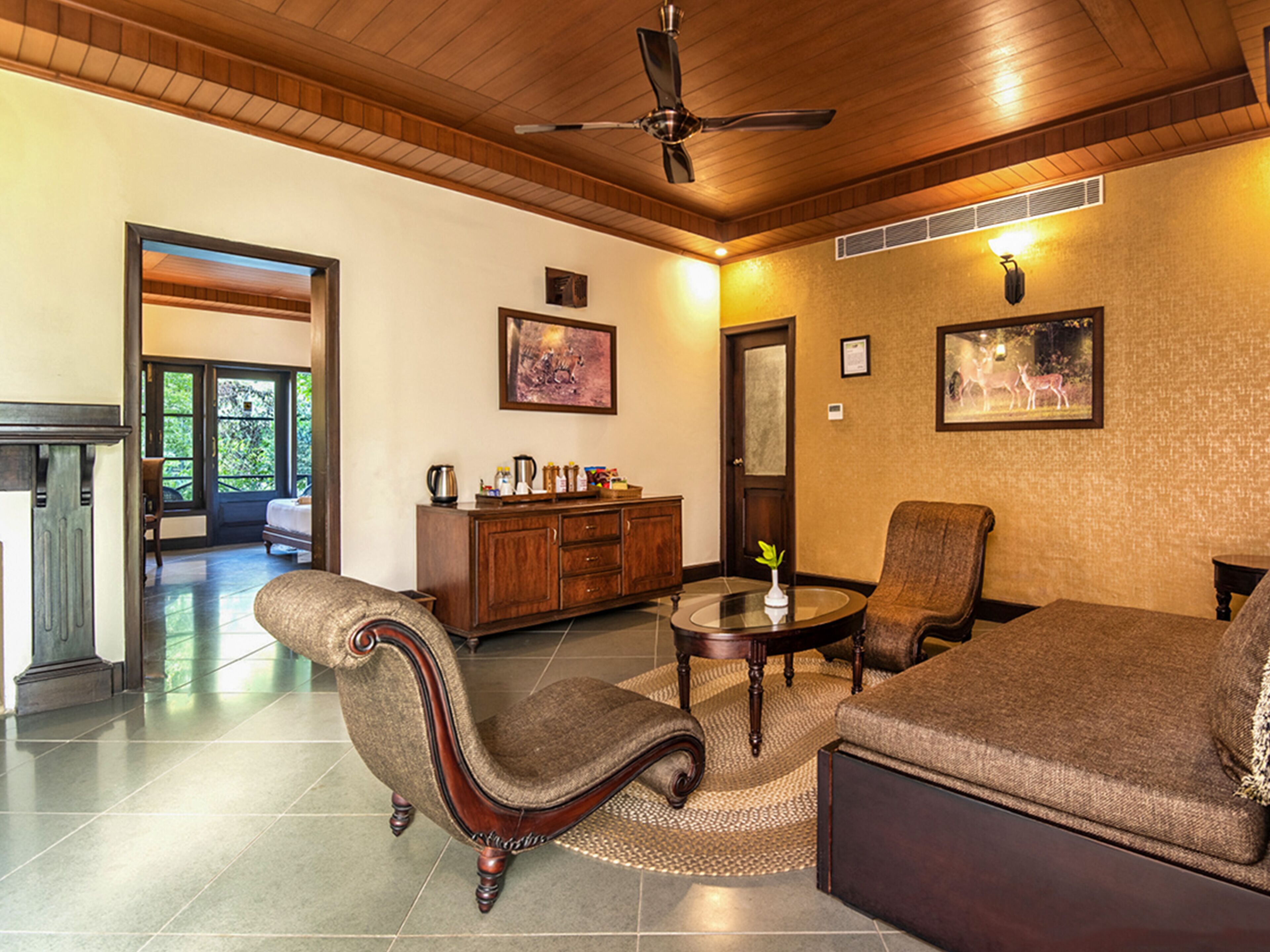 A spacious living room with a fireplace, comfortable seating, and a wooden ceiling.