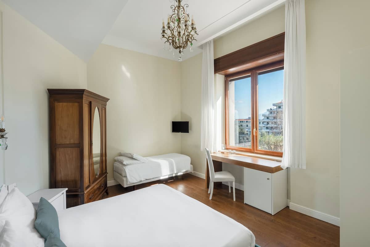 Habitación triple clásica, vista al jardín | Ropa de cama hipoalergénica, edredón y minibar