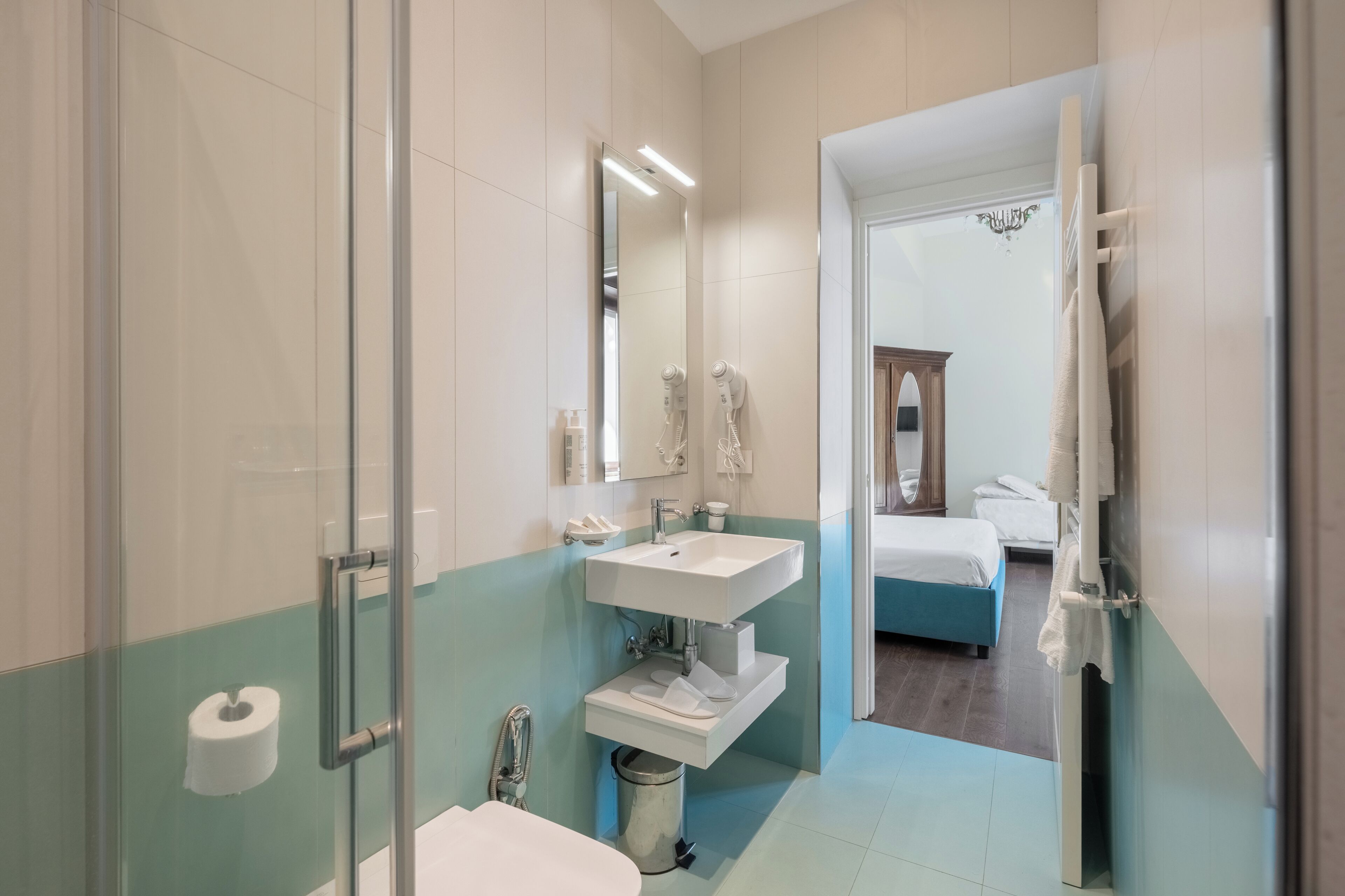 Un baño moderno con cabina de ducha de vidrio, un lavabo blanco y un espejo.