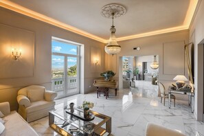 A spacious living room with a piano, a glass coffee table, and a view of the outdoors. - Experience Boutique Hotel - Villa Cimmino (Castellammare di Stabia)