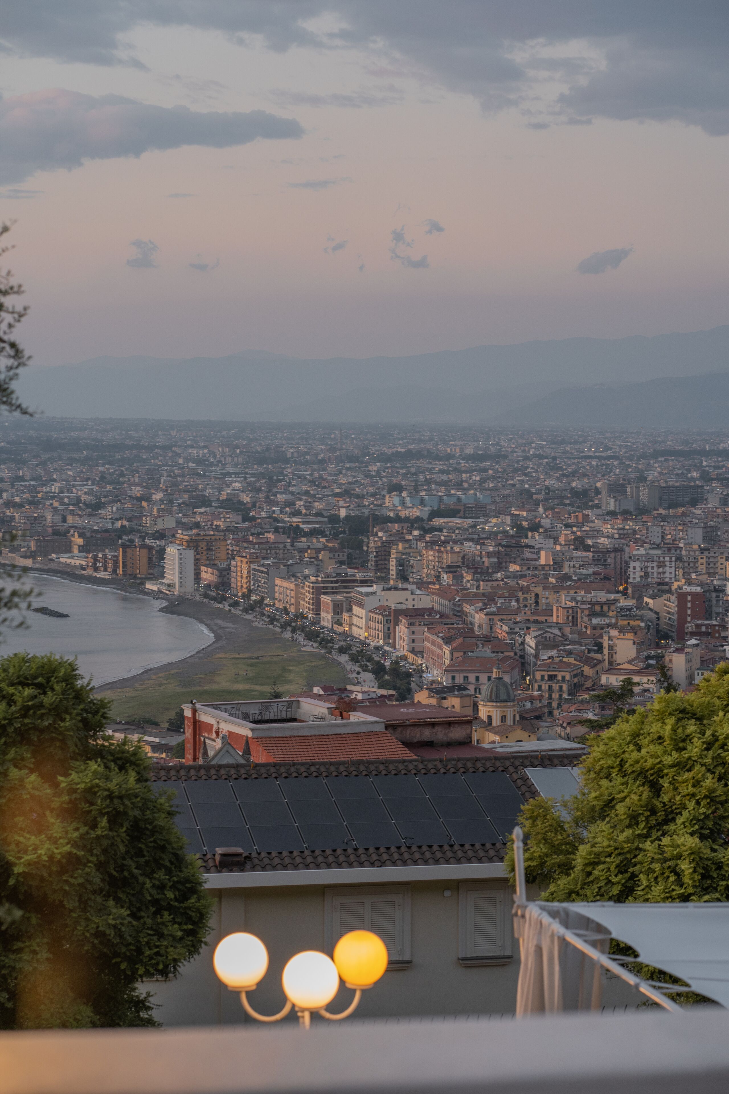 Un paisaje urbano con un río, edificios y una vista de montañas distantes.