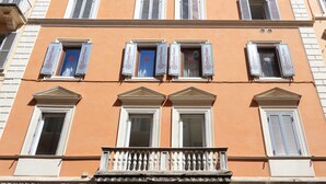 Un edificio de varios pisos con seis ventanas, cada una con contraventanas, y un letrero que dice "Downtown".