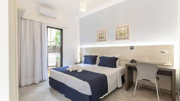 Una habitación de hotel con cama, escritorio, silla y una obra de arte en la pared.