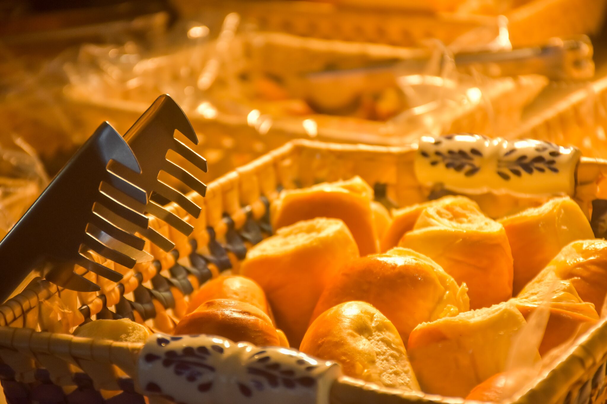 Een close-up van een fruitmand met sinaasappels en een metalen serveerbestek.