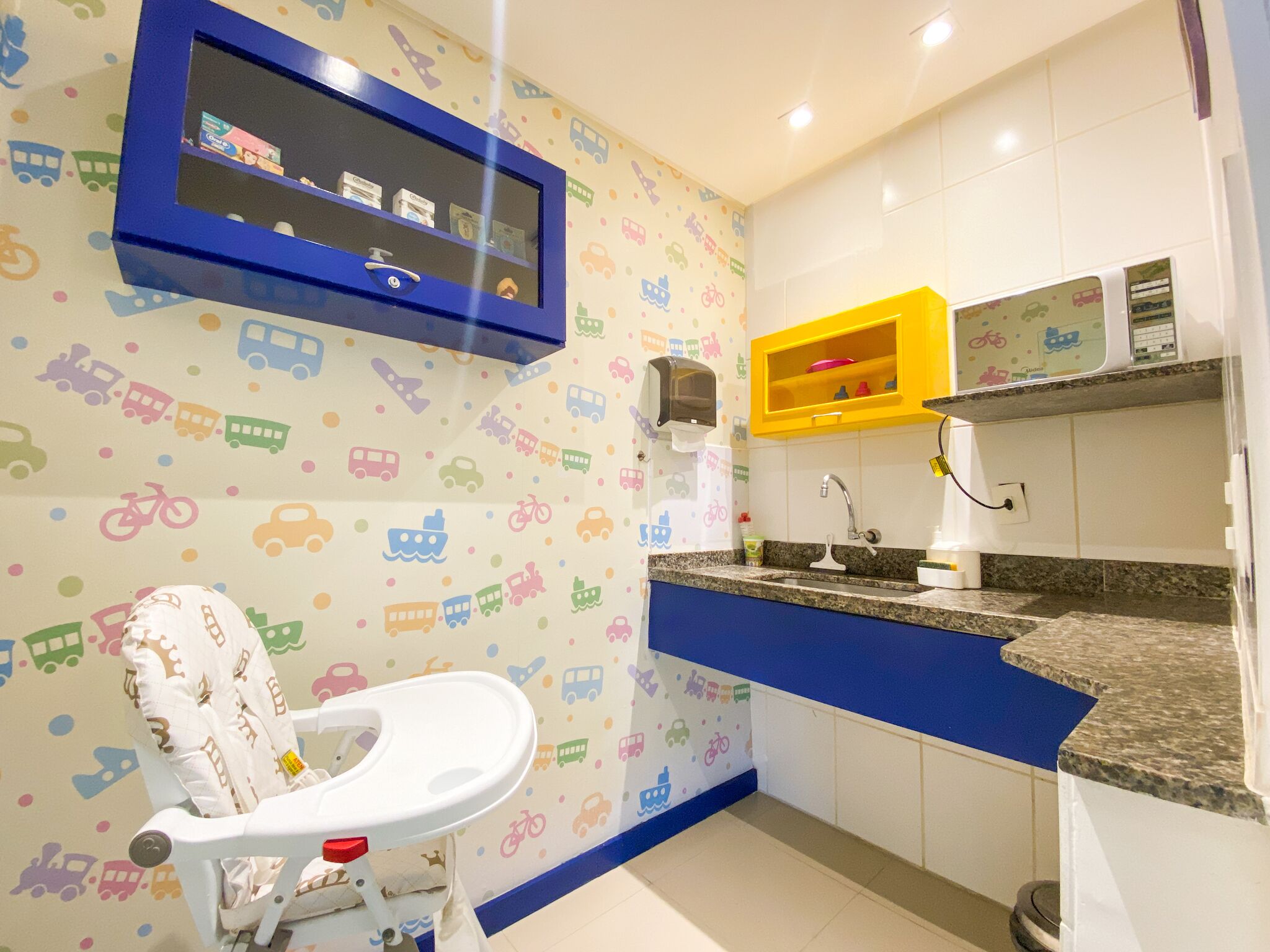 Ein Badezimmer mit Kindertoilettensitz, Waschbecken und Spiegel.